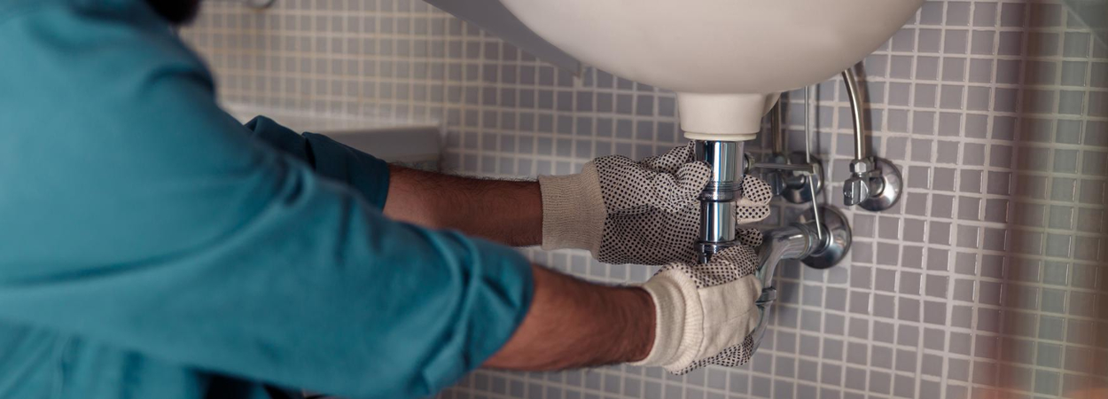 Plumber Fixing a drainage in Bathroom Sink - Plumber Pro Dallas