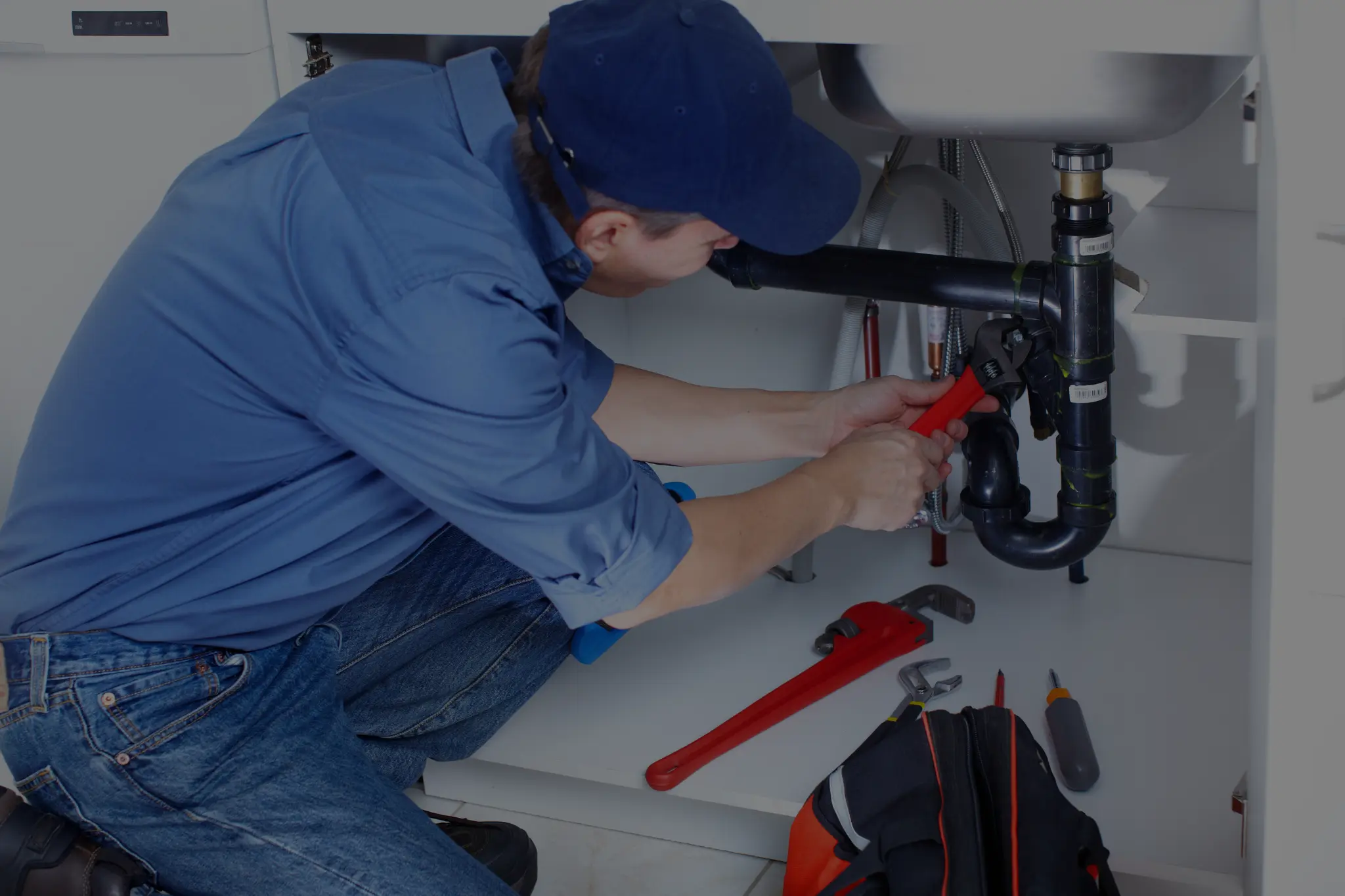 Plumber repairing under-sink drain and pipe connections – Plumber Pro Dallas