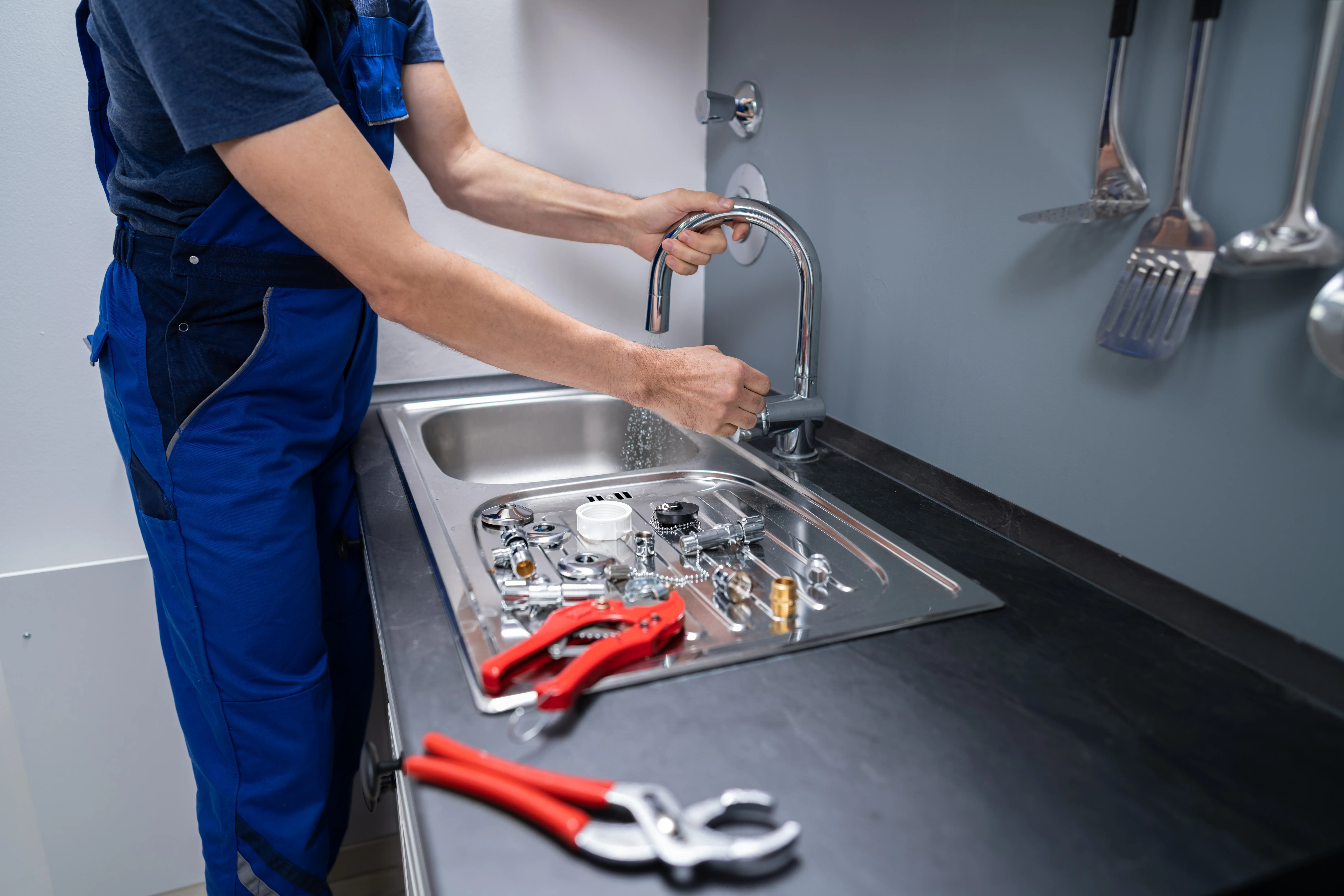 Plumber installing kitchen sink faucet and fittings – Plumber Pro Dallas