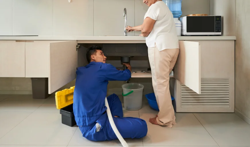 Plumber cleaning kitchen drain with homeowner assistance – Plumber Pro Dallas